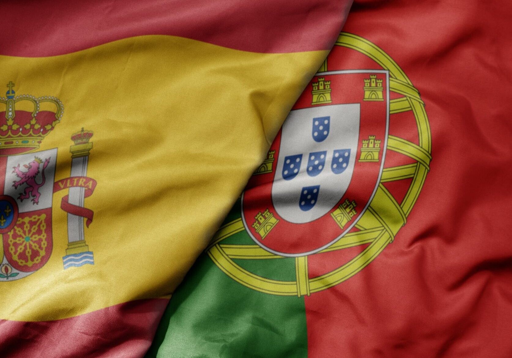A Spanish flag and a Portuguese flag are draped together.