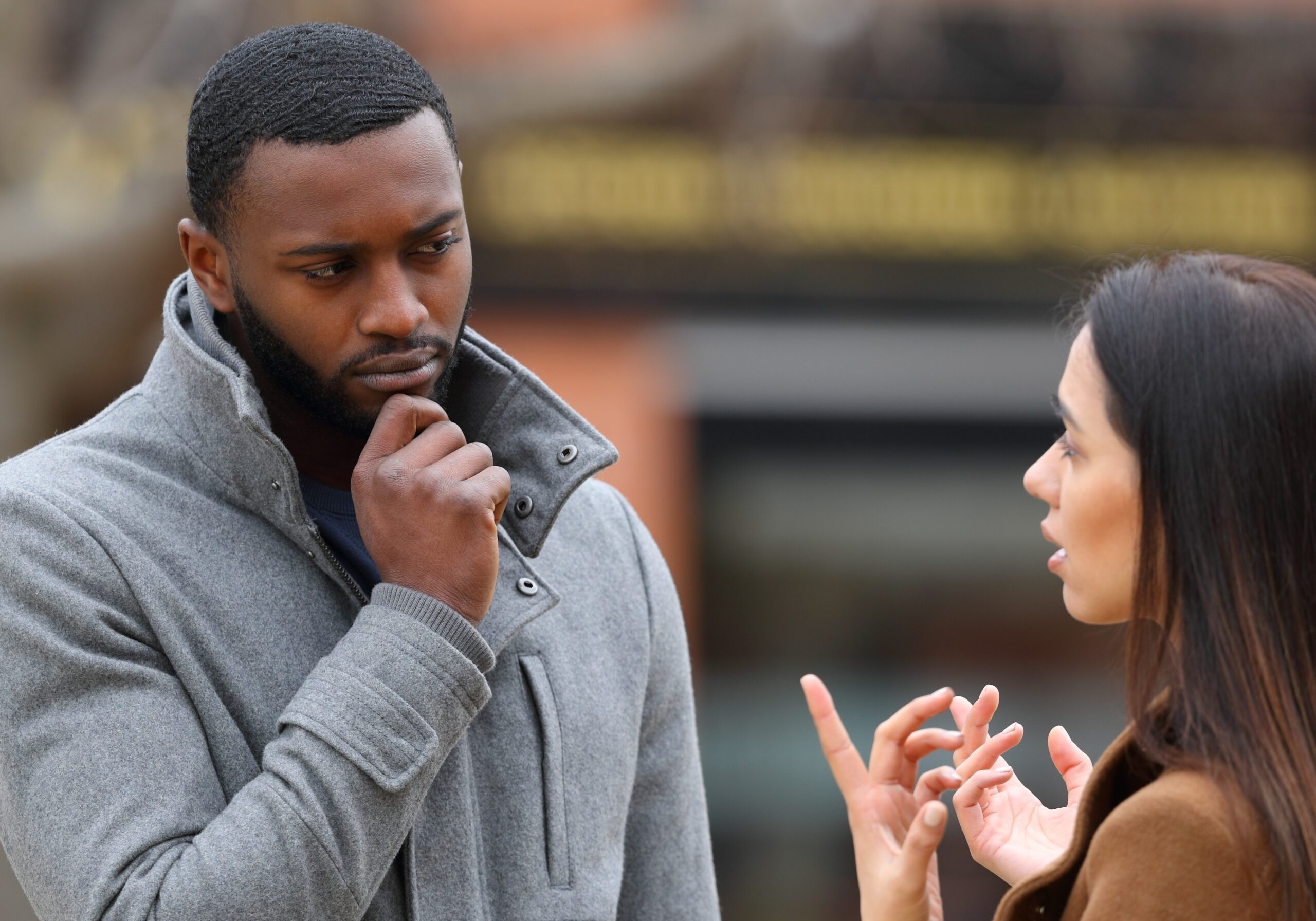 doubtful man talking with a woman and scratching his chin