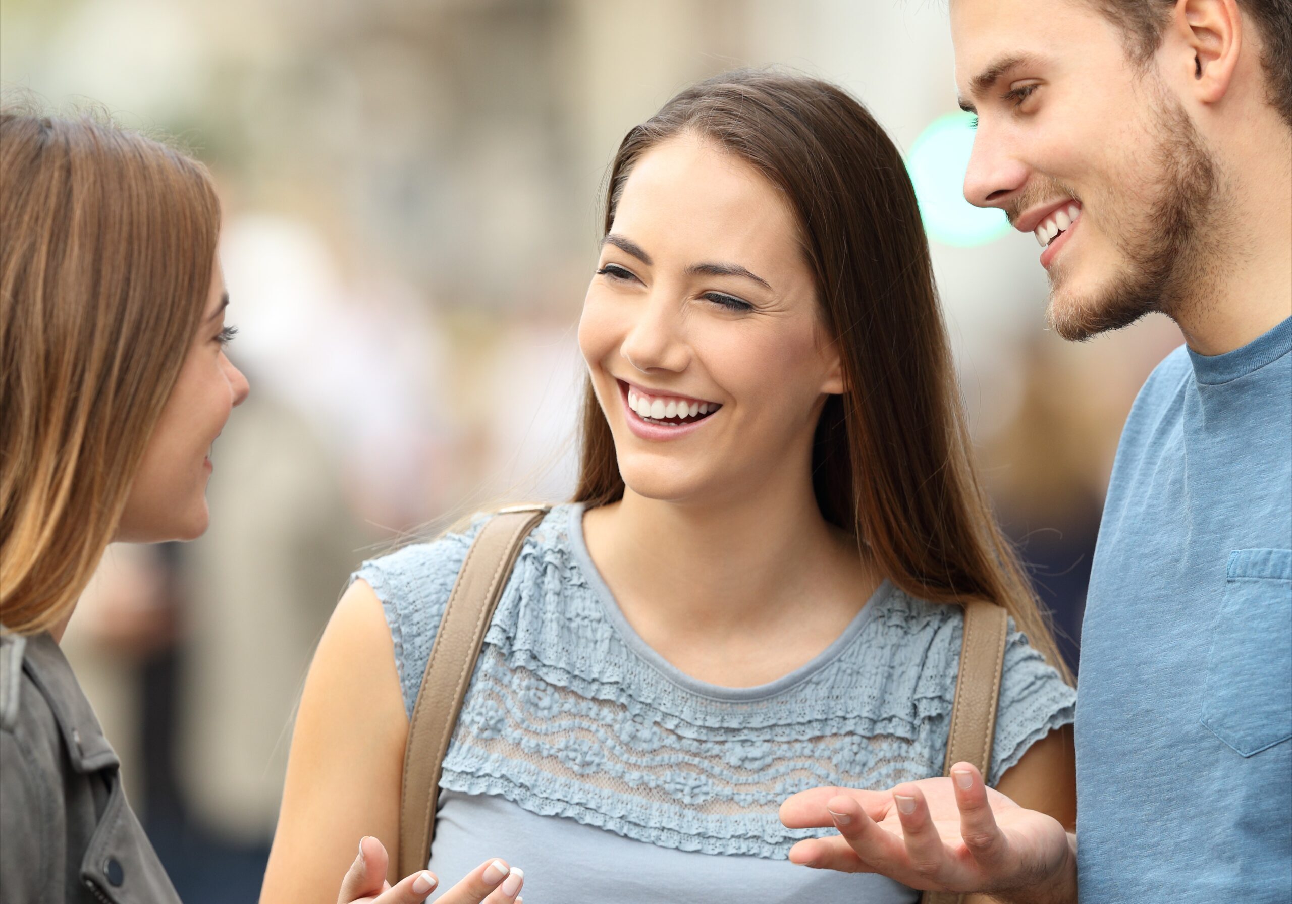 three people laughing and smiling while talking to each other