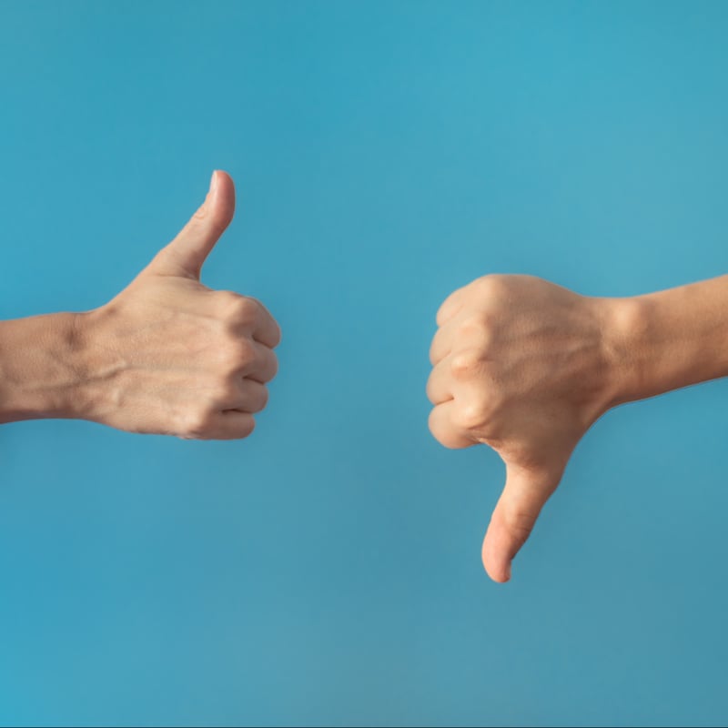 one thumb up, another thumb down