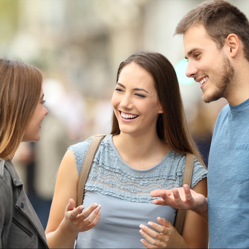 three people laughing and smiling while talking to each other