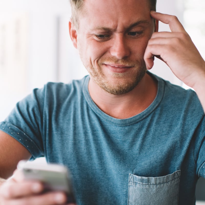 man looking confused at his phone