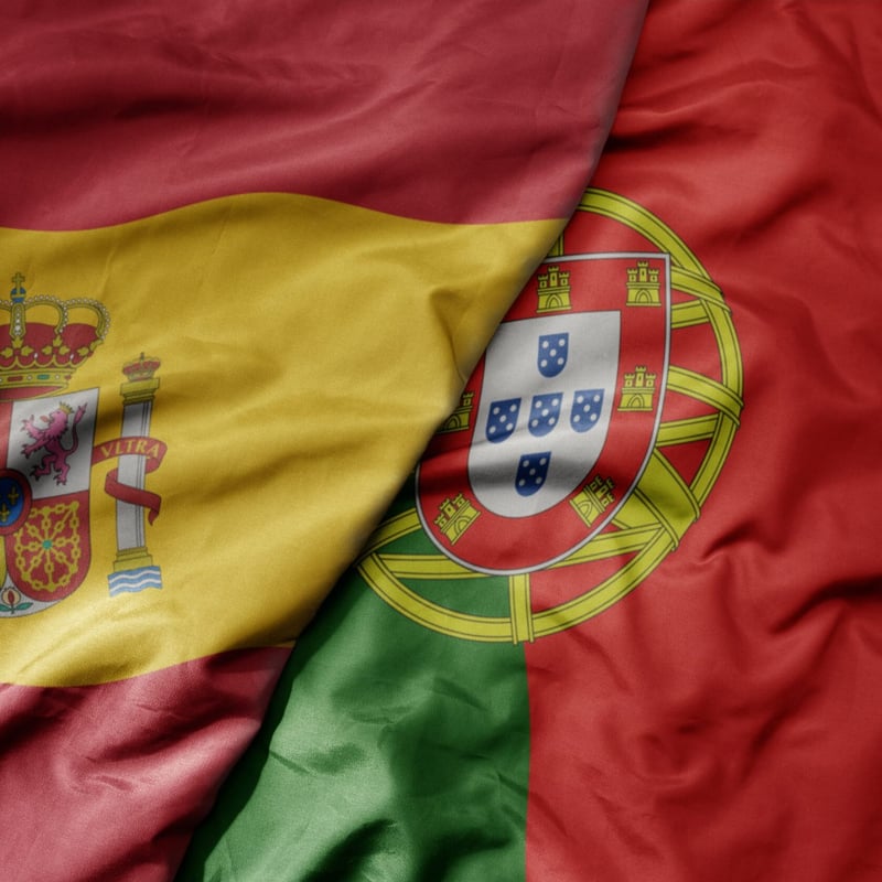 A Spanish flag and a Portuguese flag are draped together.